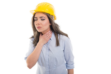 Portrait of female constructor holding her throat like hurting.