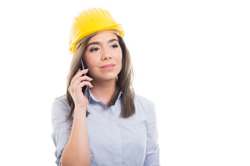 Portrait of female constructor talking at telephone.