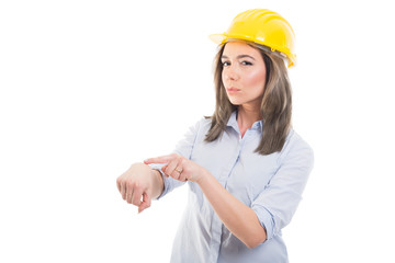 Portrait of female constructor showing being late gesture.
