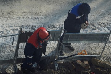 Working men in the form of standing around a sand pit