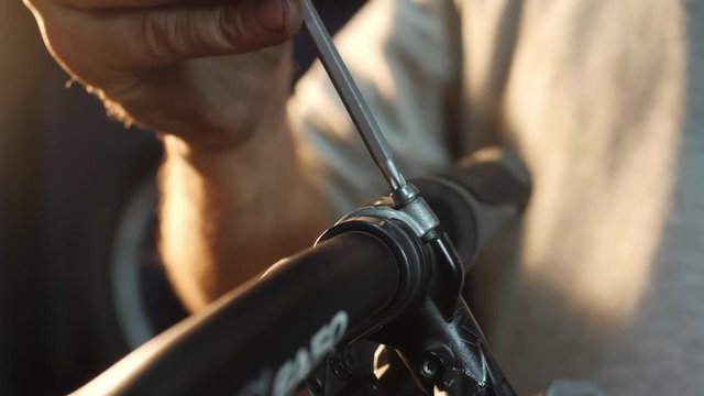 Close-uo of hands assembles a mountain bike in his workshop