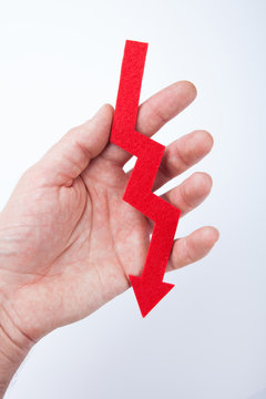 Red arrow going down in hand. Slump and recession.