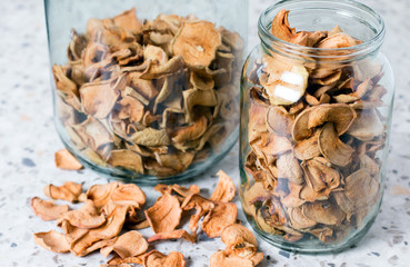 Homemade apple chips in a glass jar. Dried fruit. Healthy snack in a glass jar. Healthy vegetarian snack.