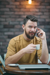 Young man sitting in cafe and using smart phone.