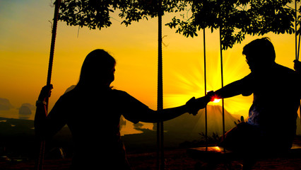 Silhouette couple over sunset background