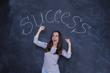 I'm a super worker. Happy successful confident business woman smiling and screaming with joy against the background of a blackboard