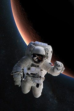 Fototapeta Astronaut in outer space on background of the Mars. Elements of this image furnished by NASA.