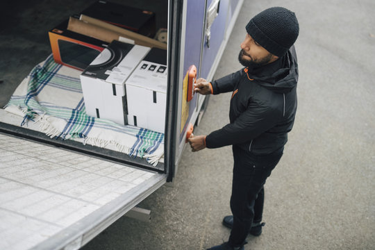 High angle view of worker opening van trunk by pushing buttons on street