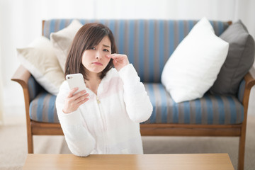 くつろぐ女性・スマホ・ソファ