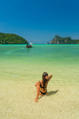 Fototapeta na wymiar Woman relaxing on the beach in Koh Phi Phi Don in Thailand