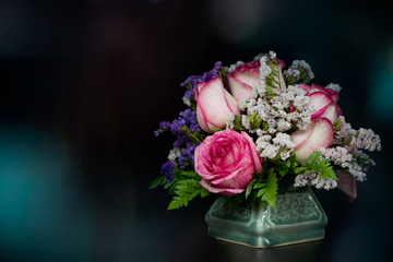 pink-white roses in vase with bokeh background
