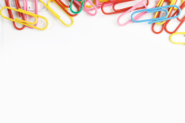A lot of colorful paper clips on white background.