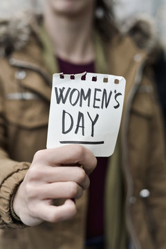 woman with a note with the text womens day