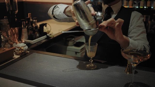 Process of preparing and service of classic traditional cocktail - honeymoon. Professional bartender shows his art of mixing alcohol drinks in secret speakeasy bar