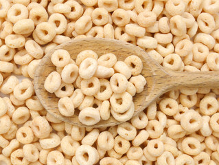 healthy cereal rings and wooden spoon on background