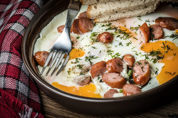 Tasty cooked egg with chopped sausages.