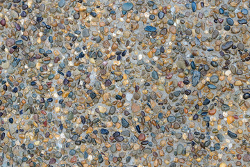Colored round stones in a concrete wall, background, texture