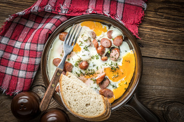 Tasty cooked egg with chopped sausages.