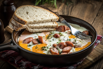 Tasty cooked egg with chopped sausages.