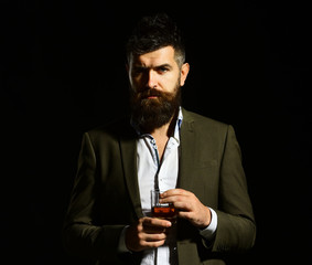 Businessman with beard and beverage on black background