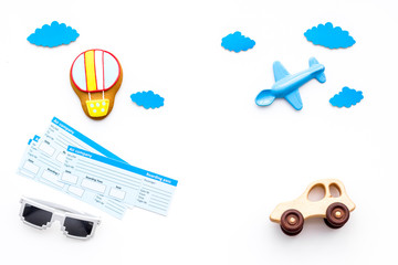 Travelling with child concept. Airplan toy, air balloon cookie, airplan tickets on white background top view copy space