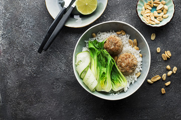 Meatballs, rice, bok choy bowl on a gray background with a ceramic dish. Flat lay. Top view.