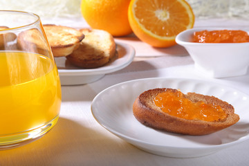 Fototapeta na wymiar healthy Morning Breakfast set with orange jam on bread toast and juice in glass.