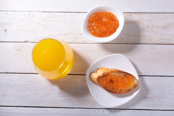 healthy Morning Breakfast set with orange jam on bread toast and juice in glass.