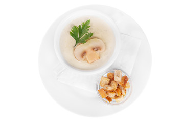 Soup puree, cream soup white, beige with mushrooms, championons and crackers, dry bread. On a napkin in a white plate isolated white. Serving dishes in a cafe, restaurant, for a menu. View from above
