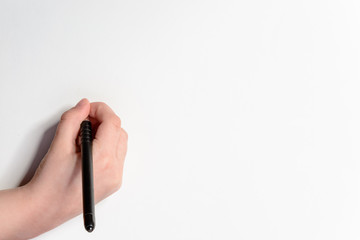 Hand of a little boy with a black pen on a white background