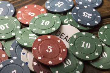  Stacks of poker chips on wooden table. The poker table. Poker chips on a dark table.