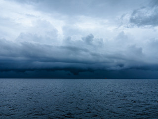 Dark blue sky and dark blue sea color and storm raining cloud background.