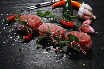 Raw beef fillet steaks mignon on dark background