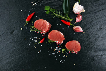Raw beef fillet steaks mignon on dark background