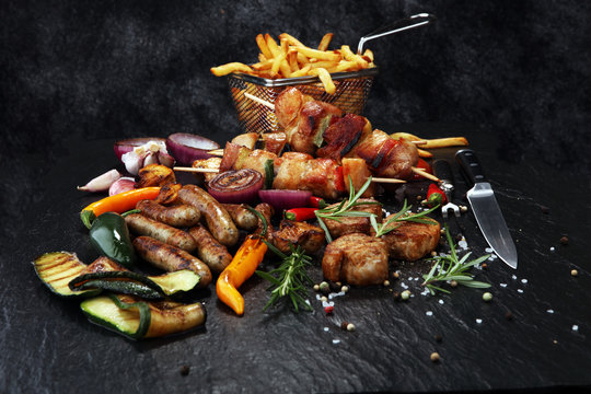 Assorted delicious grilled meat with vegetable and frites on a barbecue