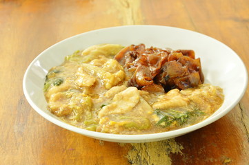fried large rice noodles dressing with chicken and vegetable in gravy sauce on plate