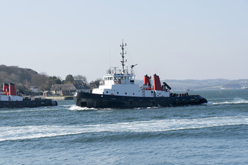 Obraz premium Plymouth, Devon, England, UK. Ocean going tug SD Adept underway departing Devonport Harbour. February 2018
