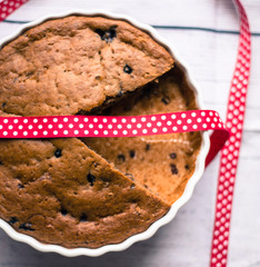 Pie with blueberries in ceramic bowl with ribbon on wooden table