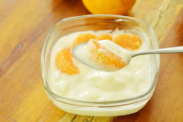 yogurt topping orange scooping on spoon in glass cup