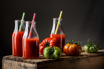 Obraz na płótnie Canvas pomidory i sok pomidorowy w butelkach