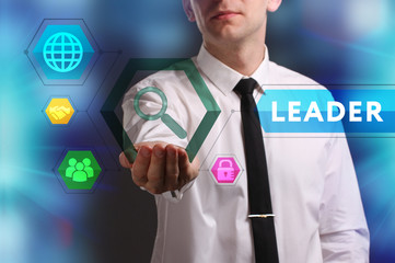 Business, Technology, Internet and network concept. Young businessman working on a virtual screen of the future and sees the inscription: Leader