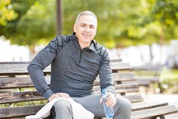 Middle aged man resting after exercise session in park