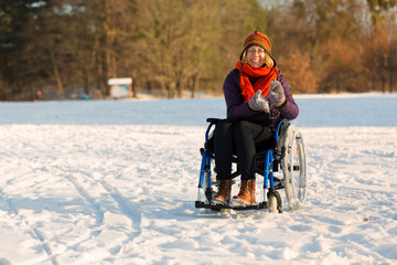 happy woman on wheelchair in the snow