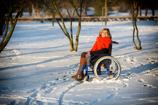 happy woman on wheelchair in the snow