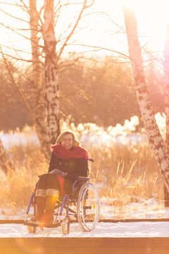 smiling handicapped woman on wheelchair in winter