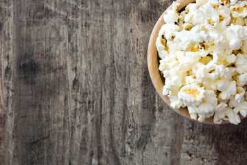 Popcorn in bowl on wooden table. Top view

