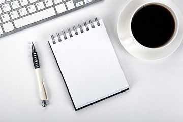 business still life of a notebook, coffee cup and keyboard on the desktop