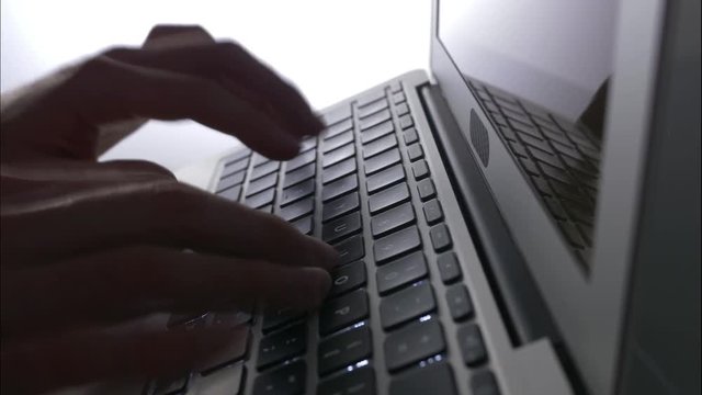 Timelapse shot of hands typing on a laptop keyboard.