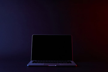one turned off laptop with blank screen on dark
