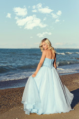 Fototapeta na wymiar woman with blue evening dress on the beach